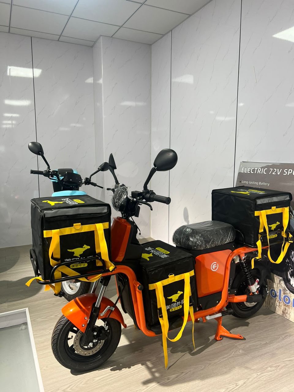 Motocicleta elétrica configurada para entrega urbana, com bagageiro e baús instalados